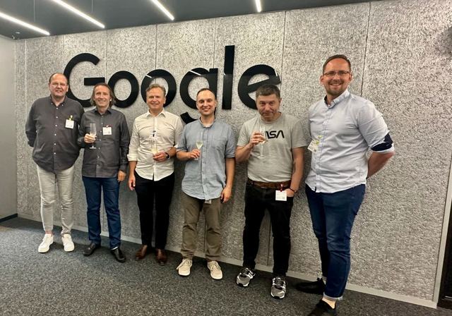 Teilnehmergruppe beim Apéro vor der Google-Logowand