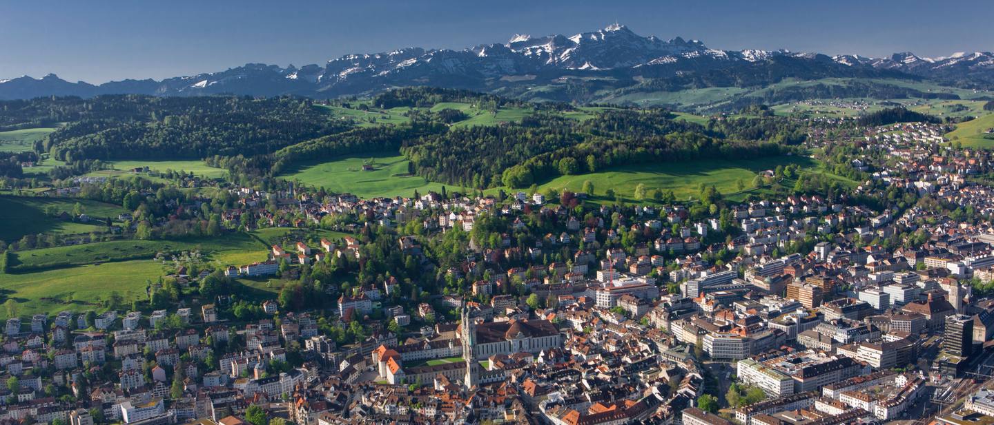 Aerial view of St. Gallen: the abbey cathedral amid the old town, with the Alpstein mountain range behind